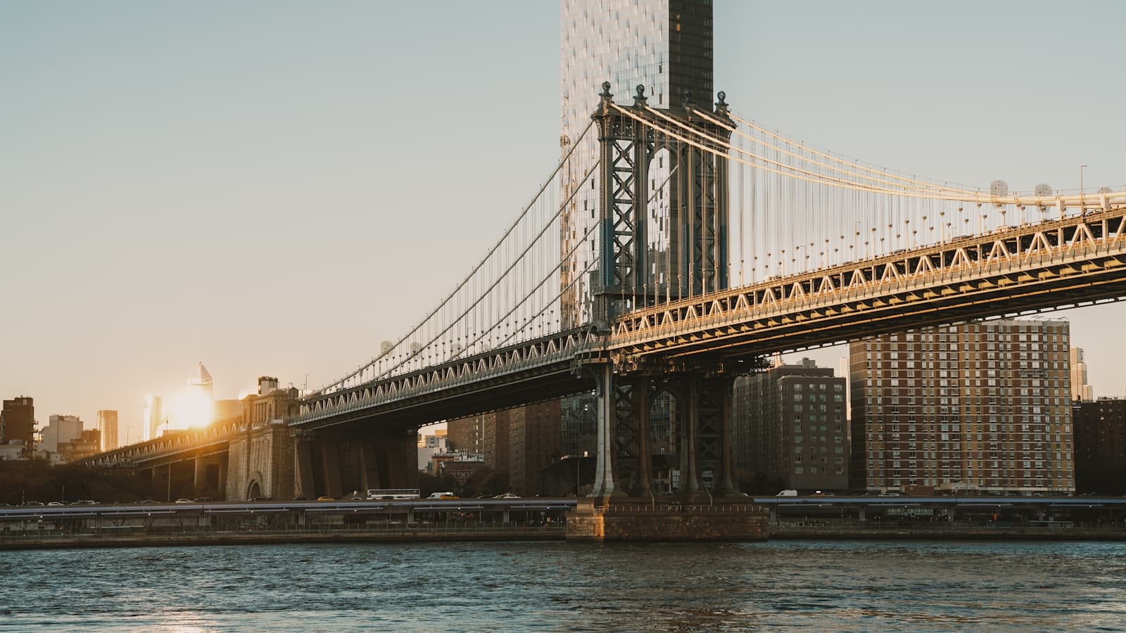 Manhattan Bridge at sunset with the city skyline behind it